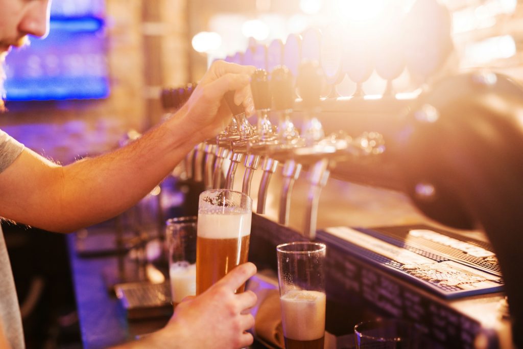 pouring beer from a tap at a restaurant bar