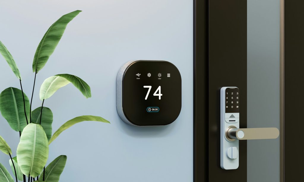 Thermostat set to 74F on a wall next to a door and a plant
