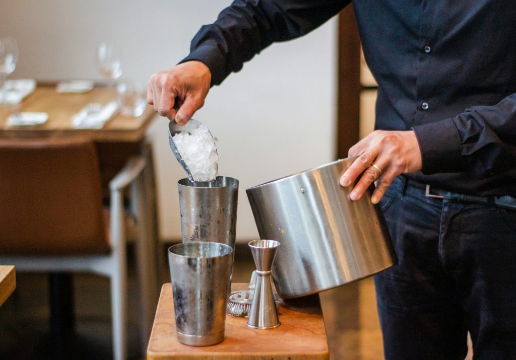 Bartender at a restaurant filling a shaker with ice